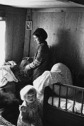 Praktikantenhilfe - Praktikantin beim Bettenmachen und Aufräumen, ein kleines Mödchen ist bei ihr; um 1970