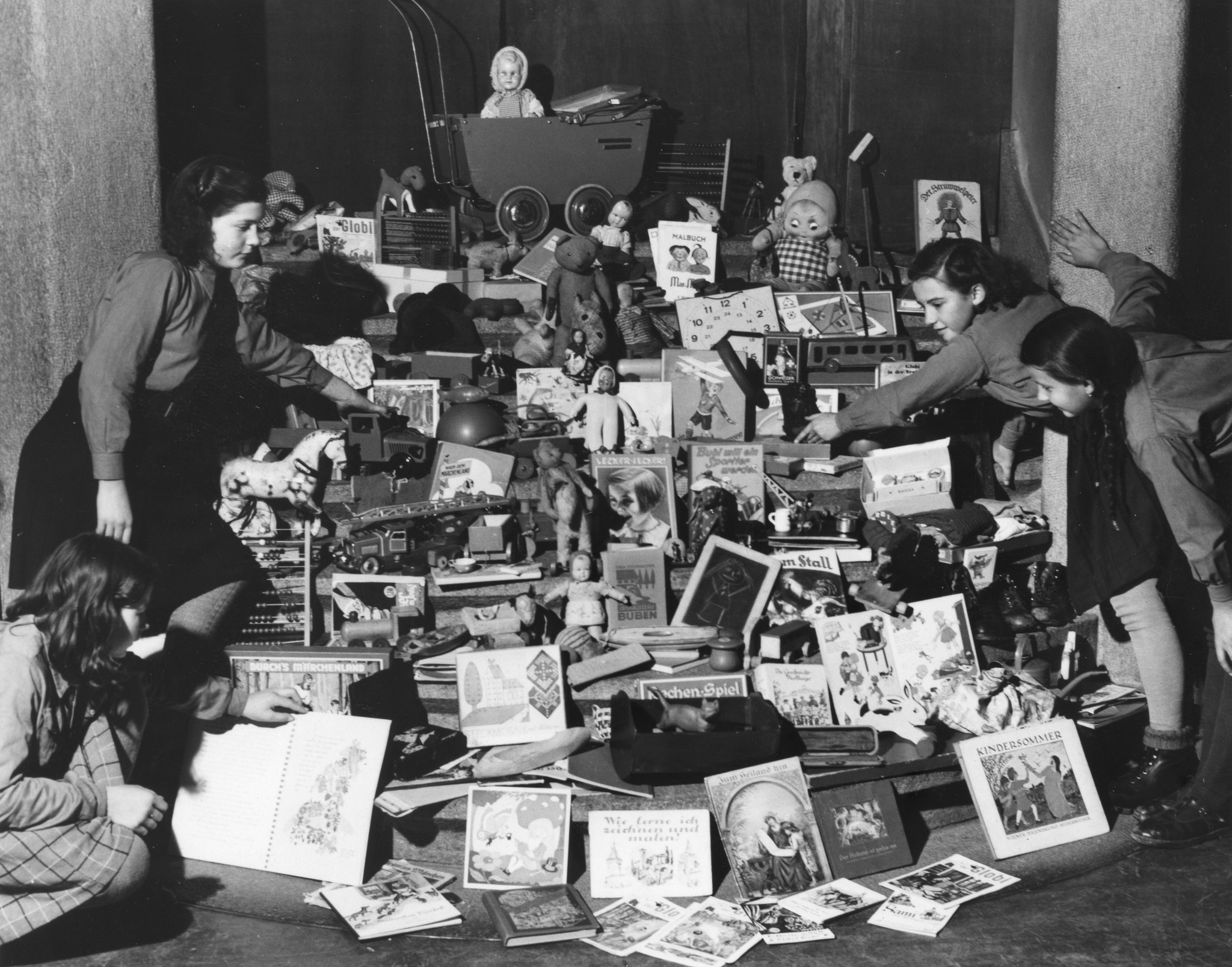 "November 1946, Spielzeugsammlung für unsere Auslandkinderheime, verbunden mit einer Kindervorstellung im Volkshaus Zürich", Kinder stellen die gesammelten Spielzeugen vor (Puppen, Plüschtiere, Comics, Globi, Kinderbücher, Spielzeugwagen,Struwwe