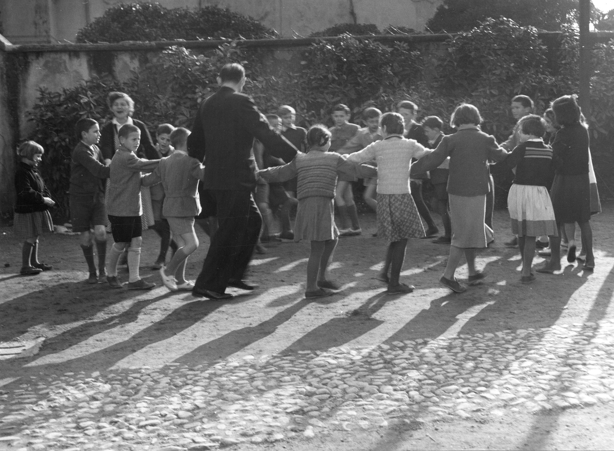 Betreuer tanzen mit den Kindern einen traditionellen jugoslawischen Tanz