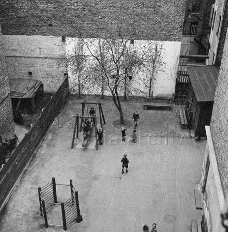 "Kopenhagen" - spielende Kinder in einem Innenhof, Klettergerüst, Wippe; um 1955
