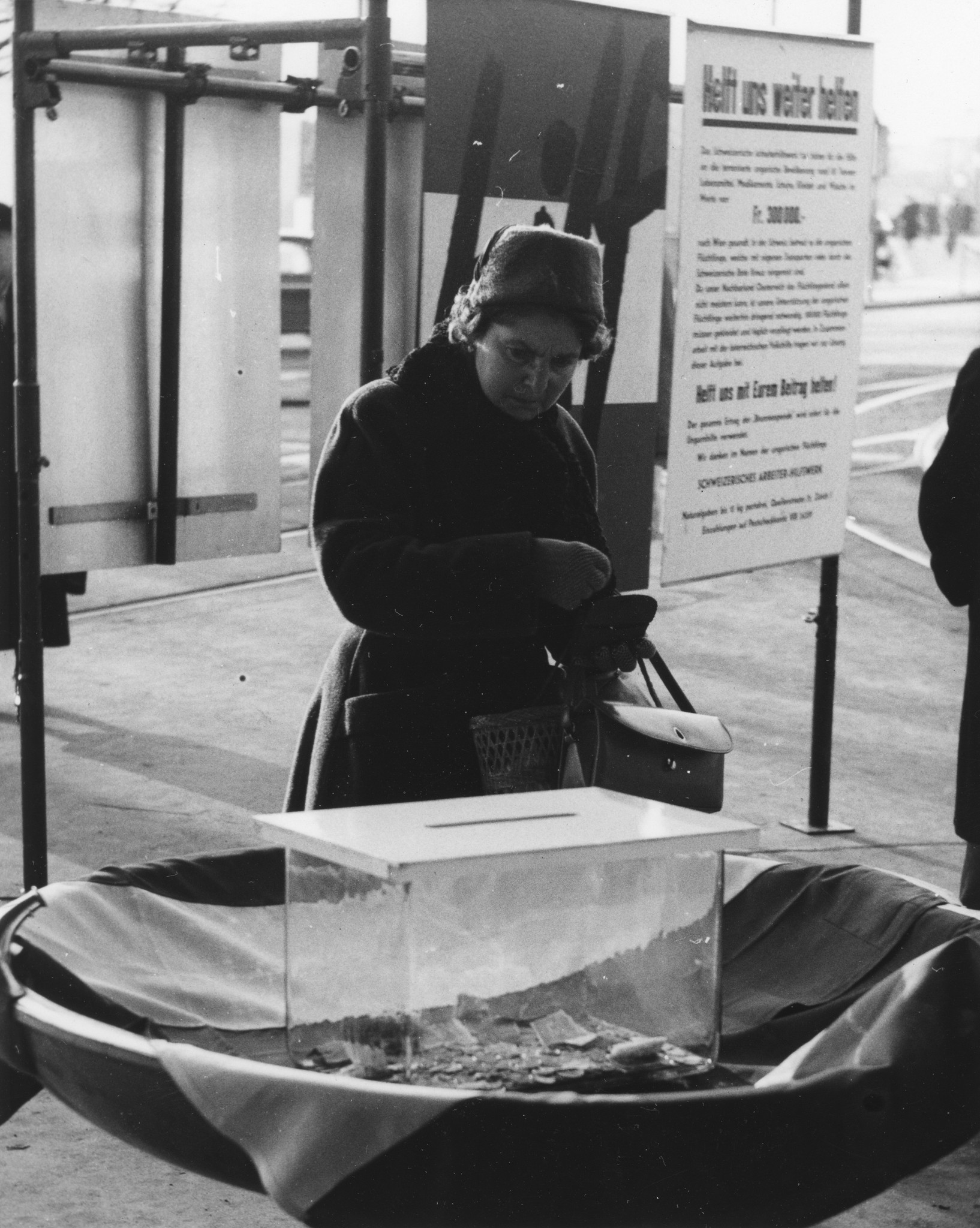 Eine Frau wirft auf dem Bahnhofplatz in Zürich Geld in einen Glasbehälter als Spende für Ungarn