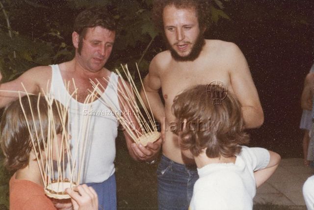 Bosco della Bella, Feriendorf für kinderreiche Familien - Zwei Männer und zwei Kinder beim Flechten von Körben; 1978