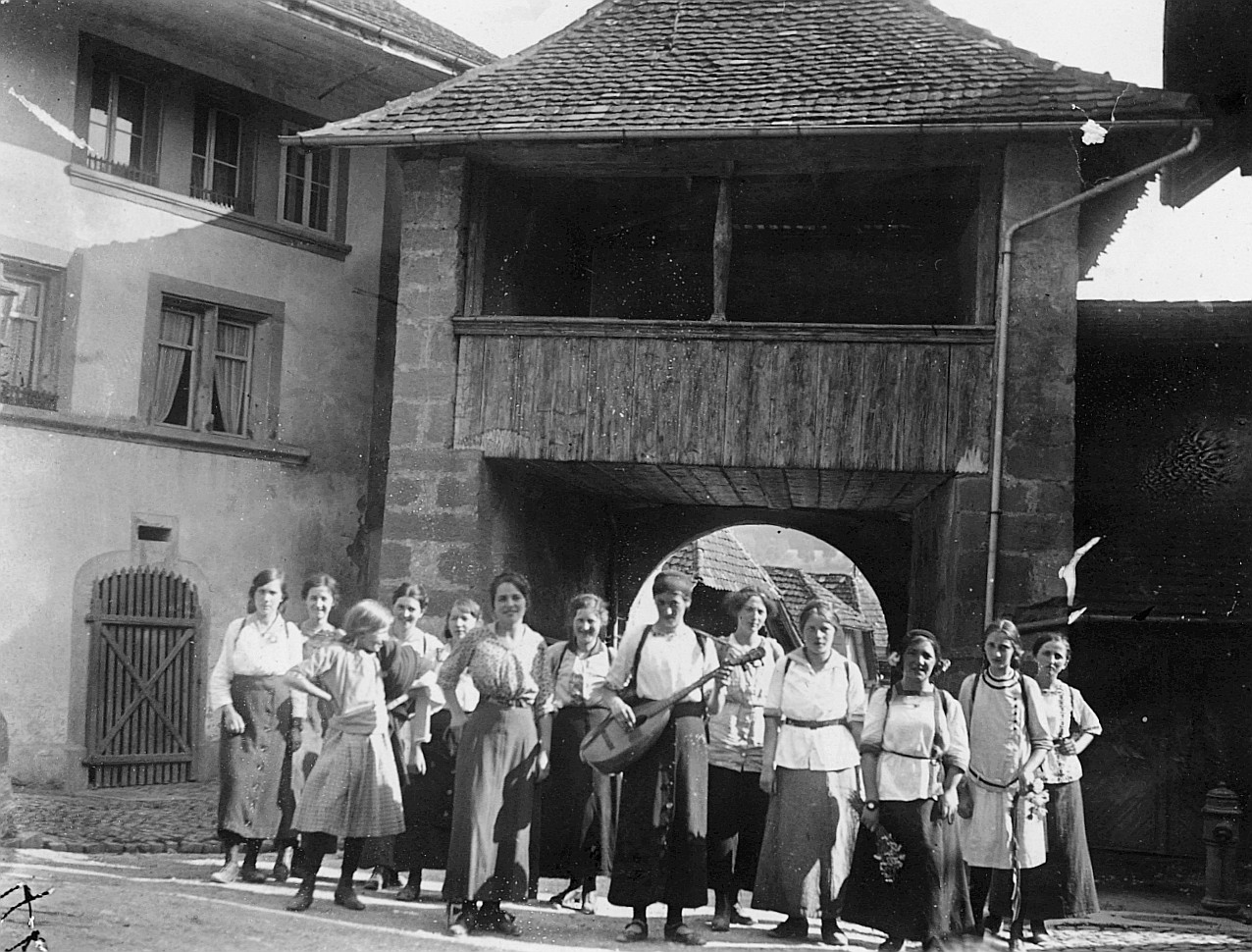 Wandervögel der Ortsgruppe Bern in Laupen - Mädchengruppe vor dem Tor (ein Mädchen Mandoline spielend) (1916)
