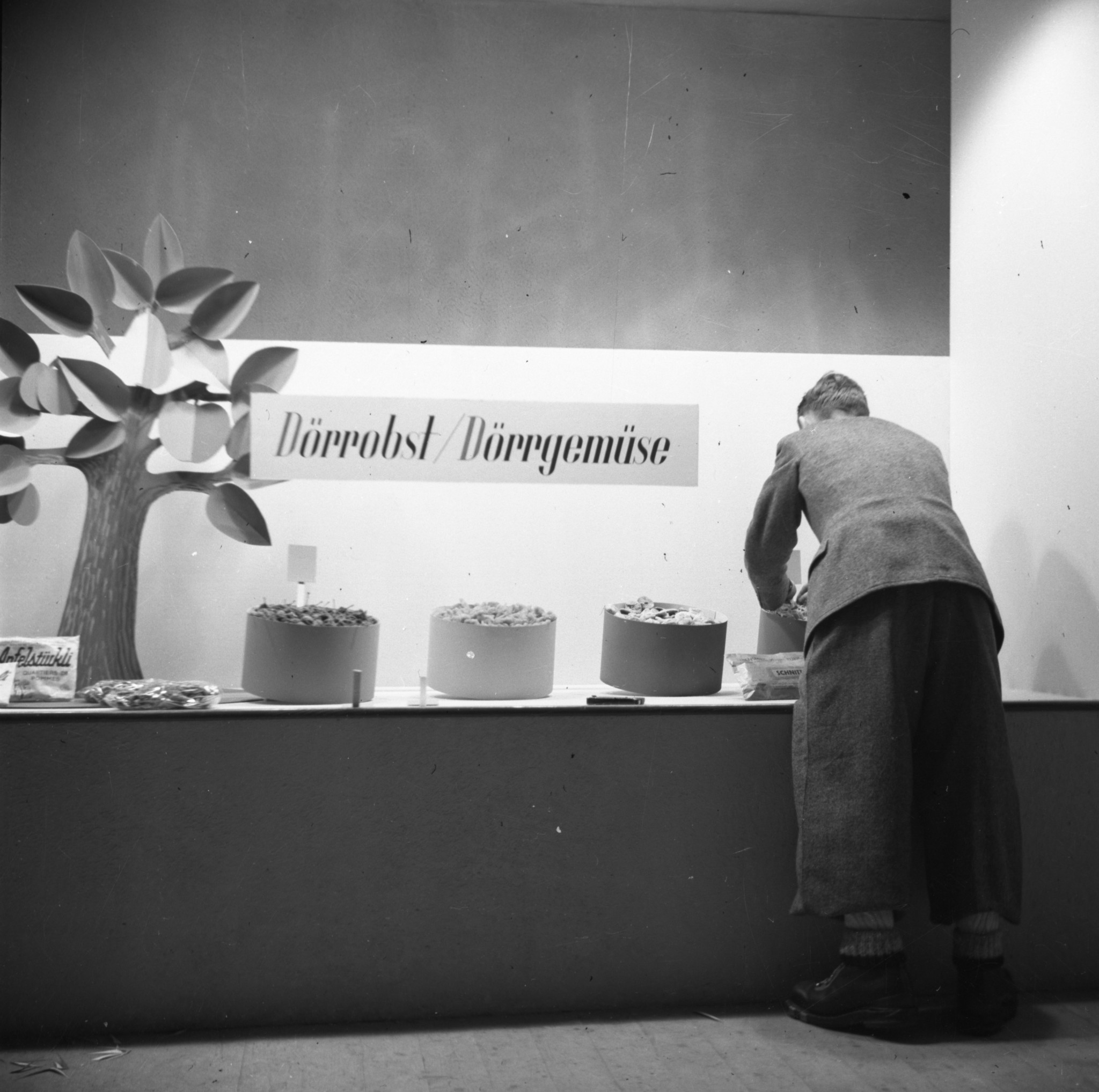 Schaufenster Filiale LVZ: Mann beim Einrichten von "Dörrobst / Dörrgemüse"