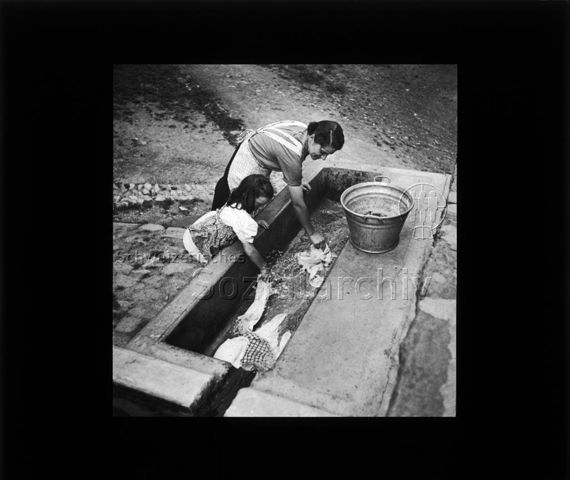Diaserie "Reserve" und "alte Dias"; eine Frau und ein Mädchen waschen Wäsche in einem Brunnen; um 1950