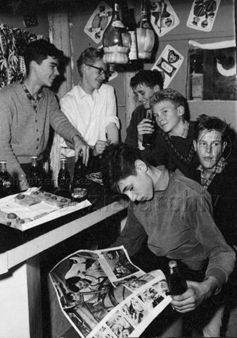 "Robinsonspielplatz Heuried" - Jungen trinken Coca-Cola, einer blättert in einem Magazin; um 1970