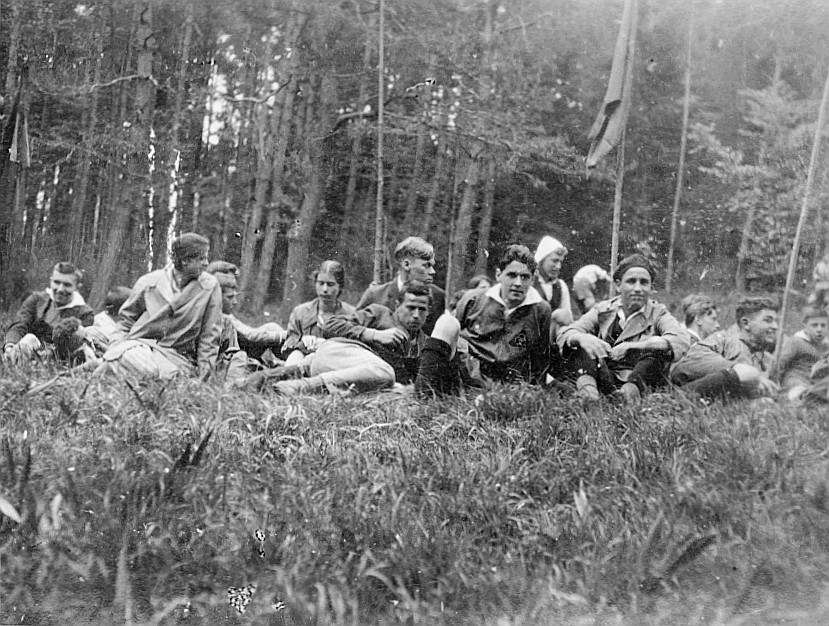 Wandervögel an der Wandervogel-Landsgemeinde in Kimenhof bei Embrach sitzen oder liegen auf der Wiese am Rand eines Waldes (Pfingste