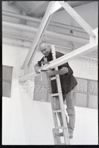 Ausstellungsaufbau, auf der Leiter