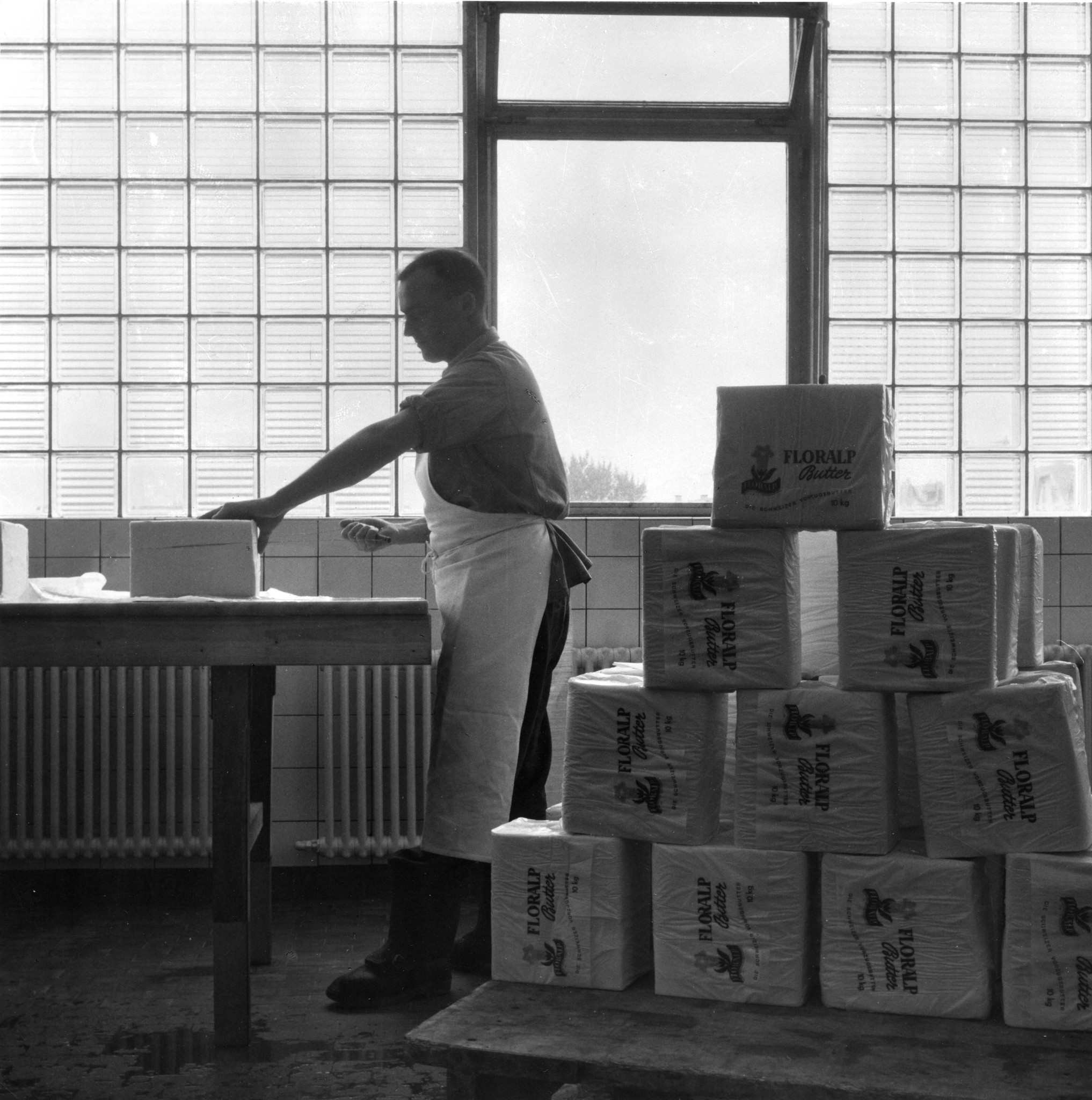 Mann beim Verpacken von Butter der Marke "Floralp"