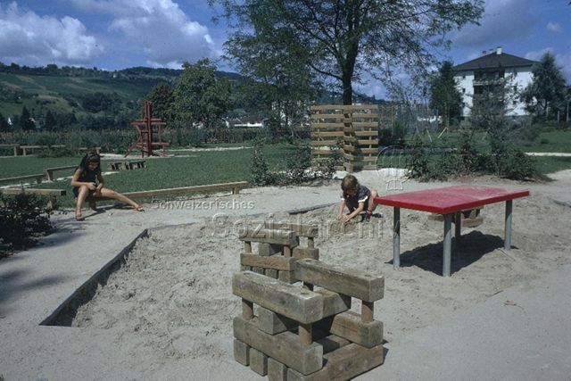 "Kinderspielplatz Riehen" - spielende Kinder, Sandspielplatz, Klettergerüst; um 1975