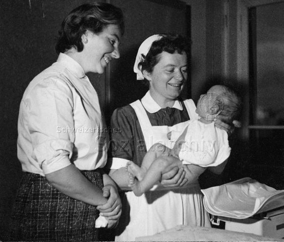 "Mütterberatung" - Zwei Frauen, eine hält einen Säugling im Arm; um 1965