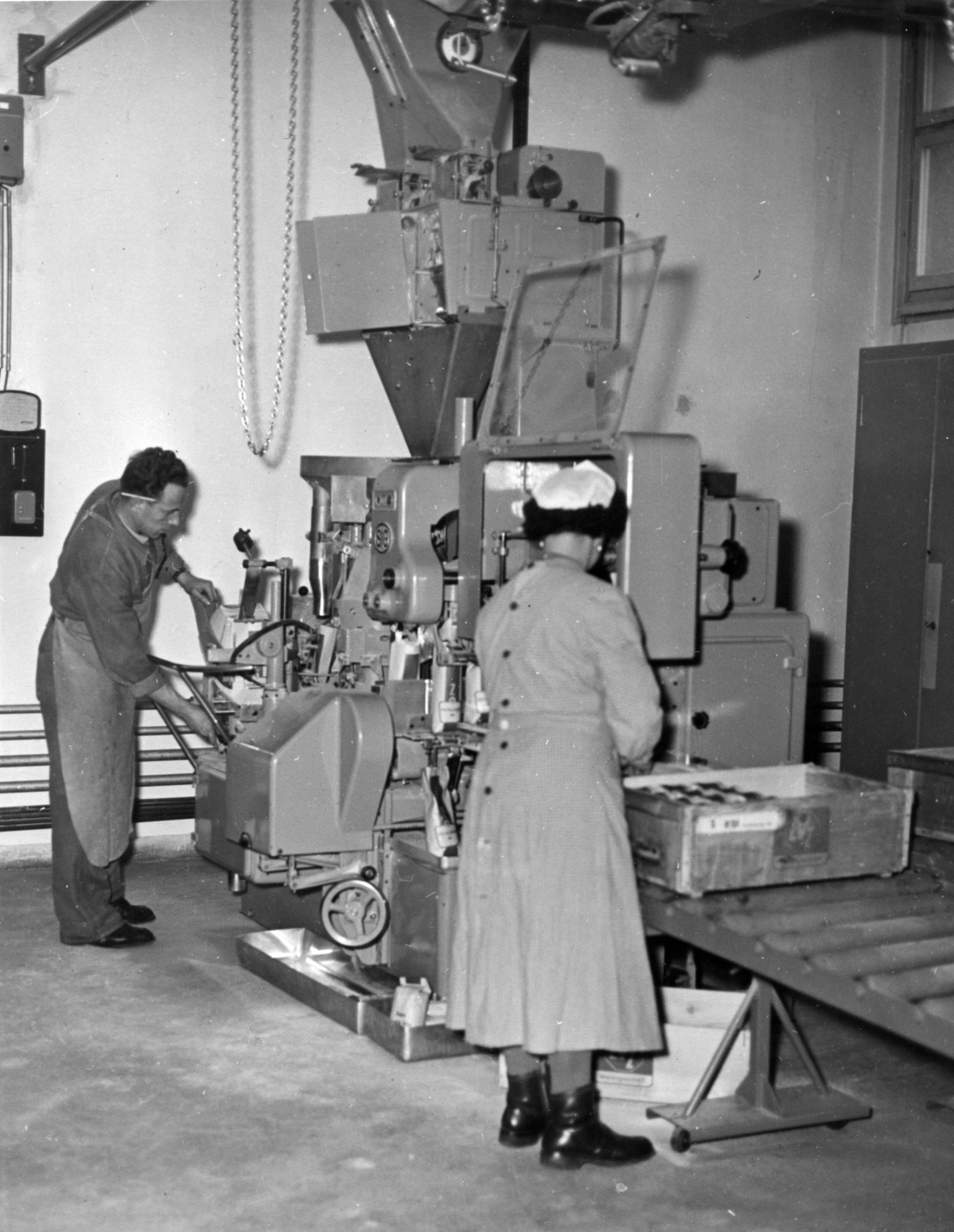 Frau und Mann bedienen eine Maschine