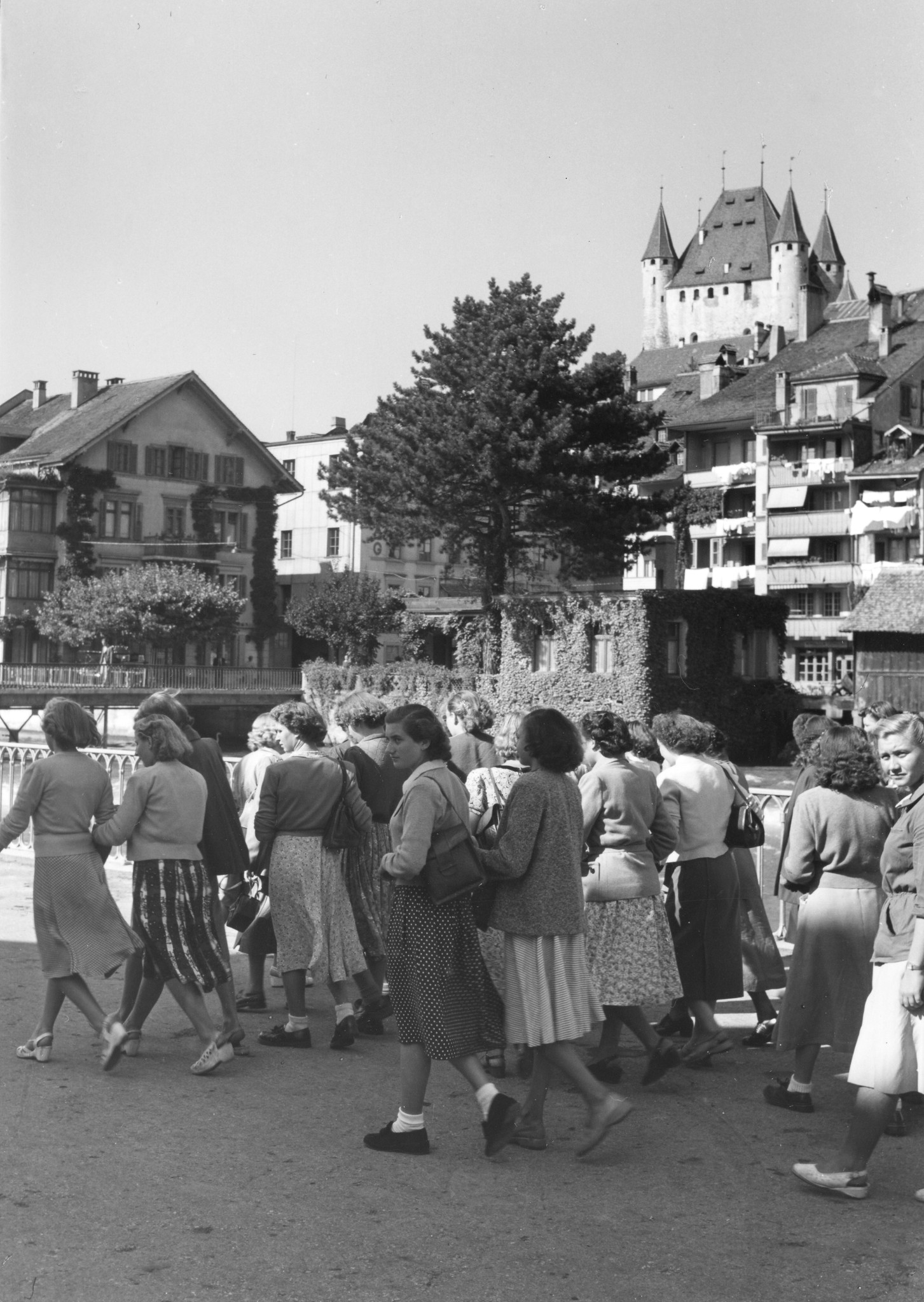 Junge Frauen laufen durch eine Stadt, im Hintergrund eine Burg