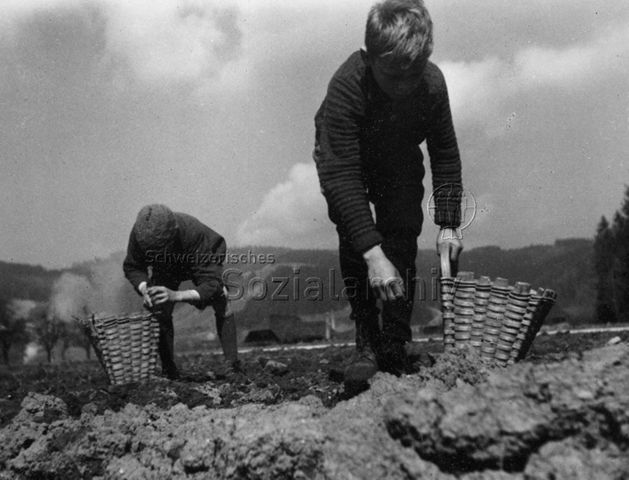 "Bergkinder" - Zwei Jungen bei der Arbeit auf dem Feld; um 1970
