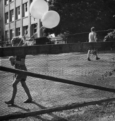 Junge mit Luftballonen auf einem Platz; um 1965