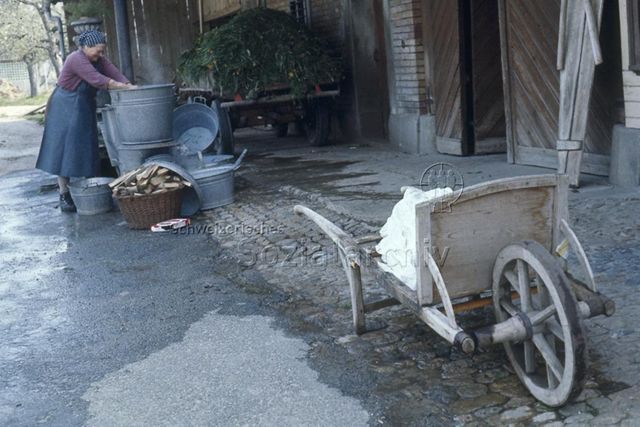 "Bauernhof Schalunen" - Bäuerin beim Waschen vor dem Hof; um 1975