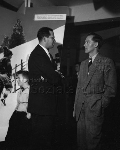 "Jelmoli, Ausstellung", Zürich (?) - Zwei Männer im Gespräch; wahrscheinlich 1962