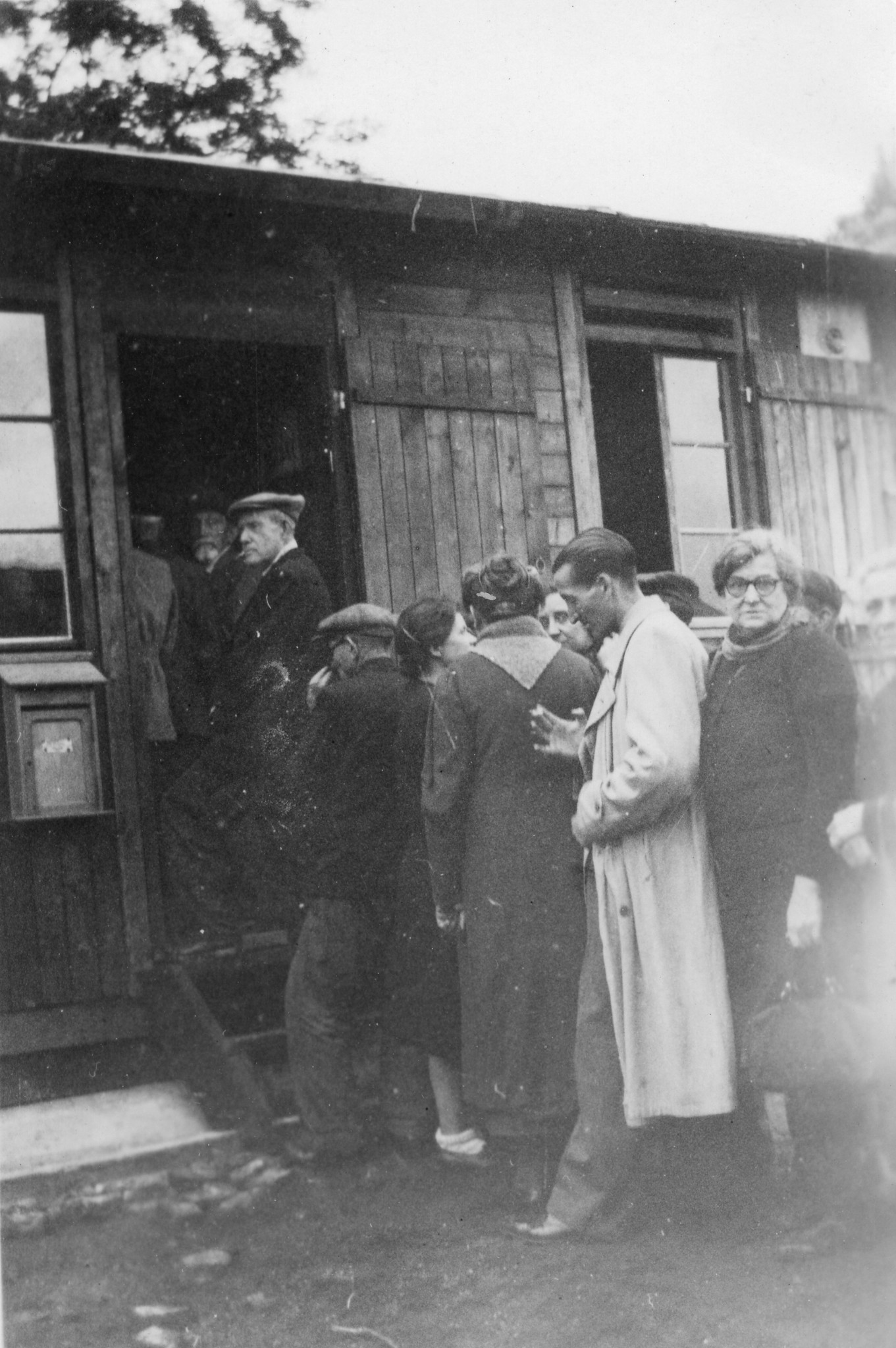 "Affluence les jours de permanence"; Andrang während der Sprechstunde; Menschen stehen vor einer Baracke Schlange