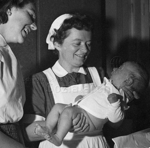 "Mütterberatung" - Zwei Frauen, eine hält einen Säugling im Arm; um 1965