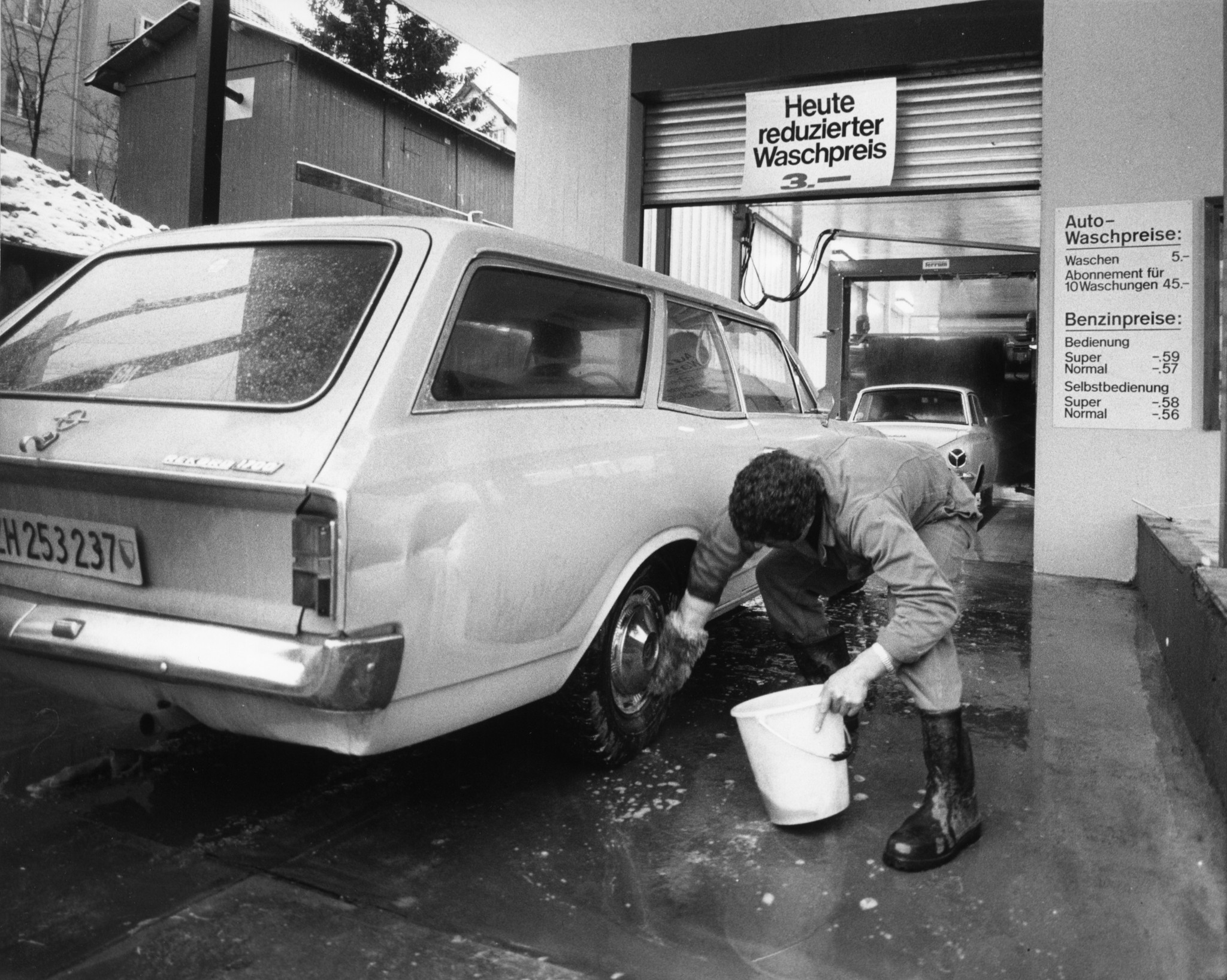 Mann beim Waschen seines Autos in der Waschanlage der Tankstelle des Lebensmittelvereins Zürich in Thalwil