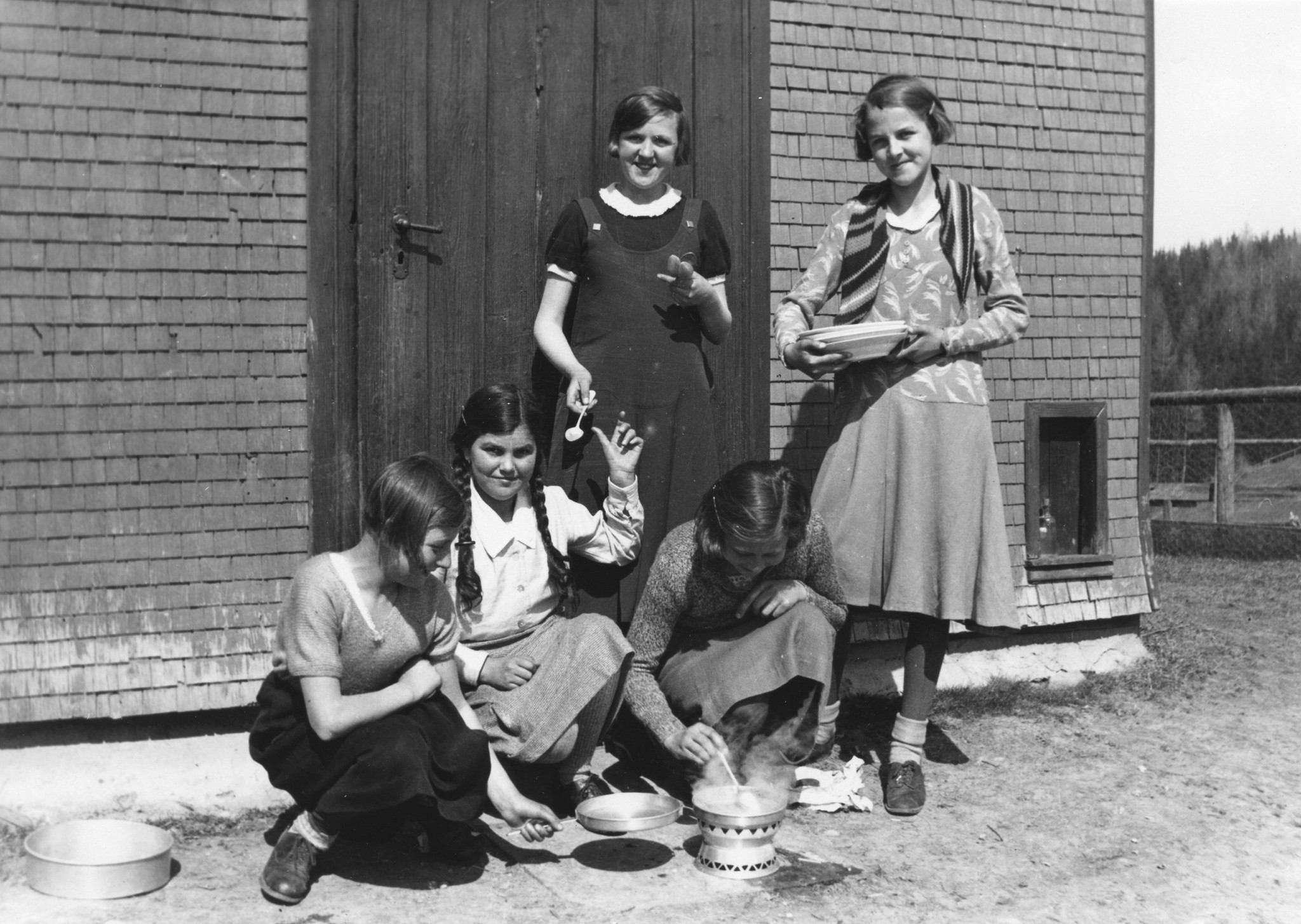 Mädchen der Steyrerkinder-Aktion [vermutlich aus Steyr (Oberösterreich)] beim Kochen unter freiem Himmel, auf dem Gräbis [nah Gais (AR)], um 1950 (Nachkriegszeit)