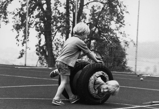 Kinder beim Spielen mit Autoreifen; um 1980