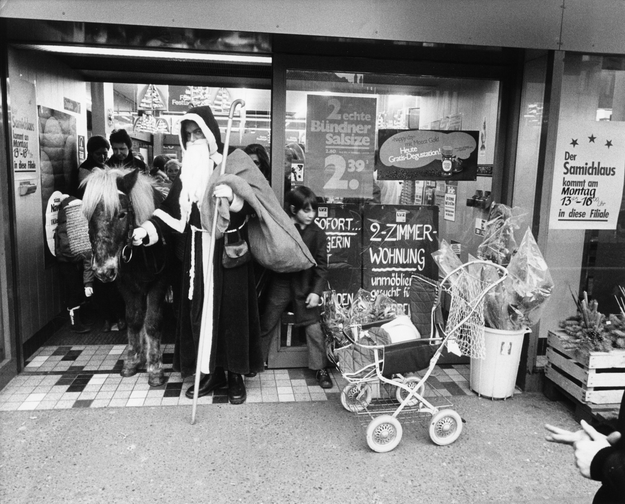 Nikolaus mit Esel neben Kunden vor einer Supermarkt-Filiale