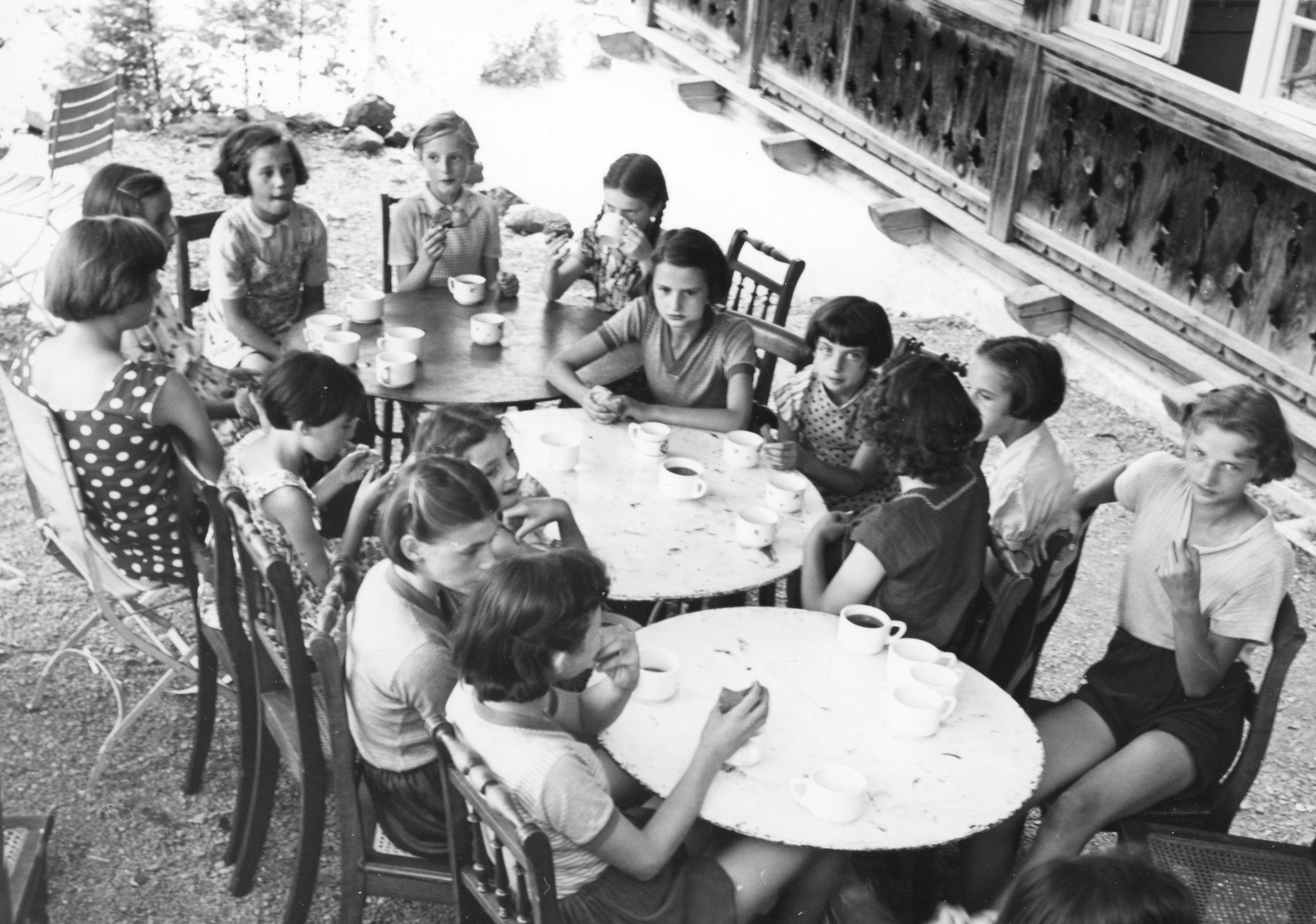 SAH Kinderlager im Sommer 1952 in Kienthal - Mädchen sitzen draussen an Tischen und trinken Tee