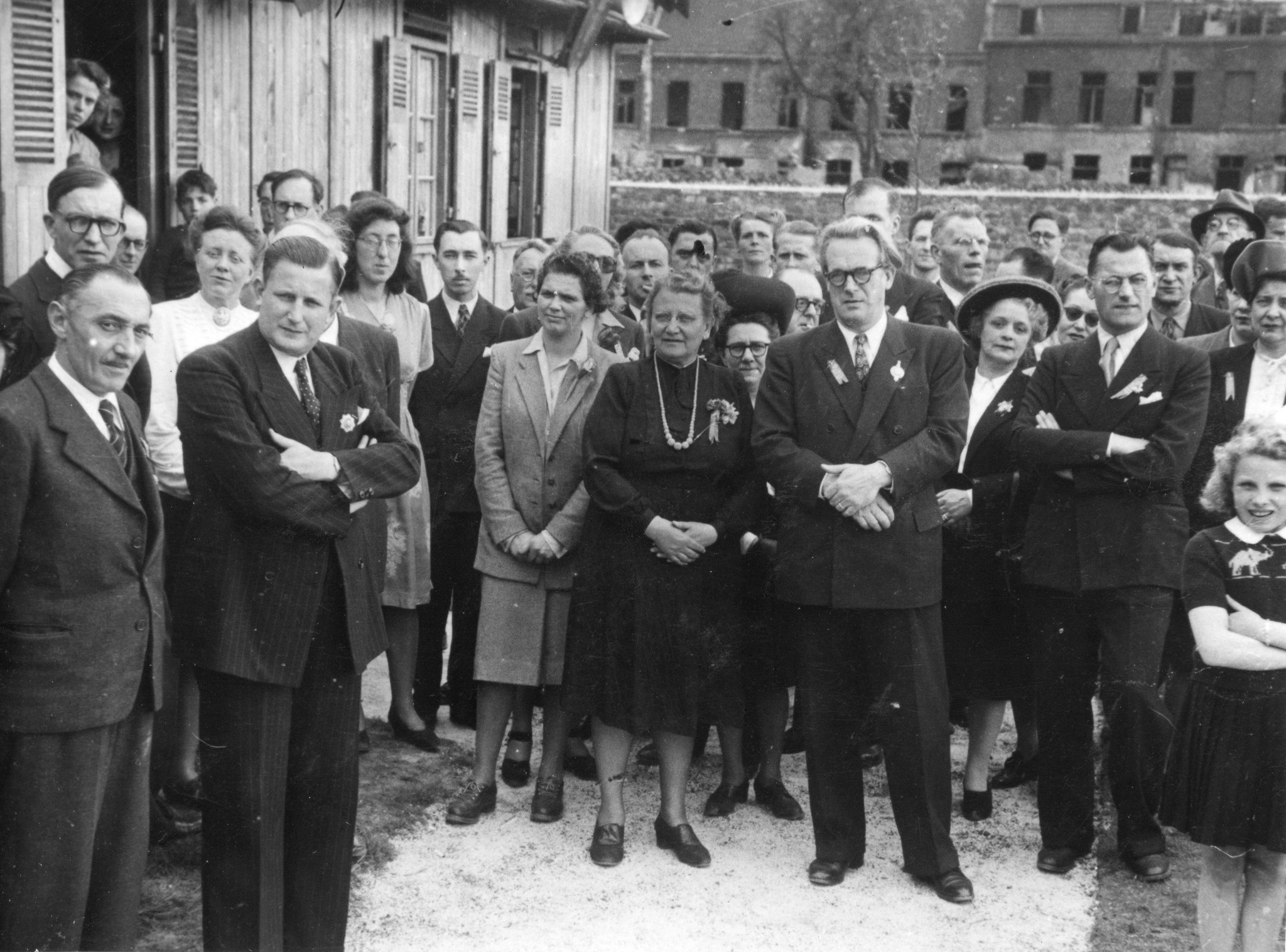 "Eröffnungsfeier des Centre social am 11. Mai 1947"; Menschen stehen zusammen, Bildmitte im dunklen Kleid: Regina Kägi-Fuchsmann