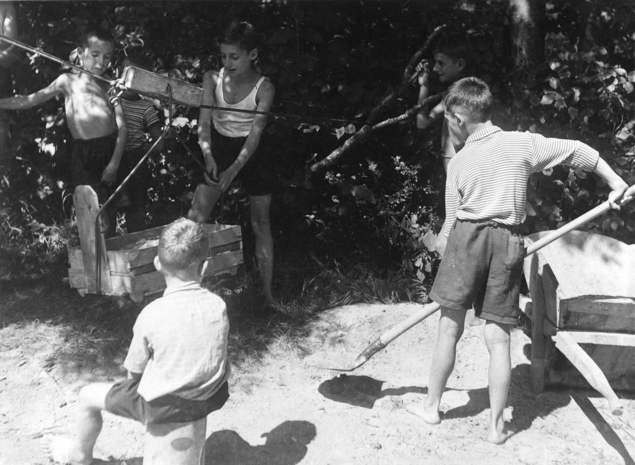 Kinder füllen eine kleine Seilbahn mit Sand auf