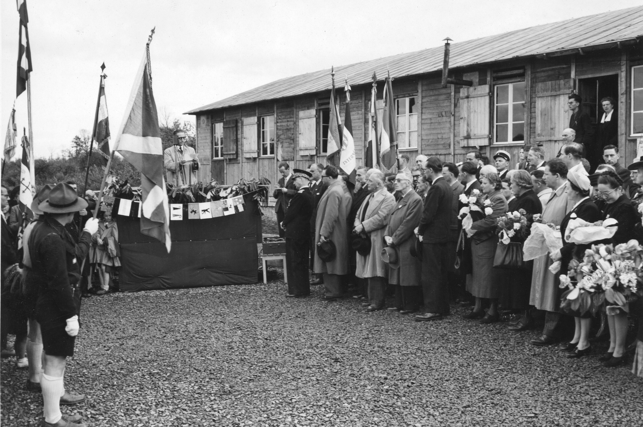 Georges Lavally eine Rede haltend, im Hintergrund das Sozialzentrum von Saint-Lô