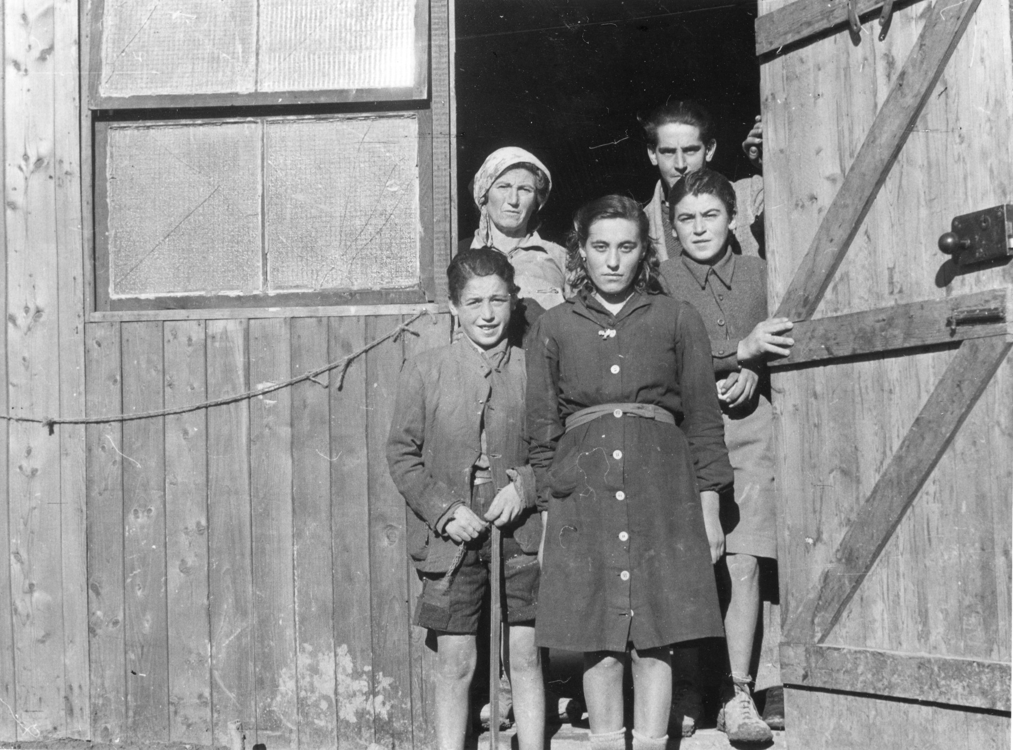 "Pianoro, Januar 1946. Eine in der Baracke wohnende Familie."; Familie steht im Hauseingang