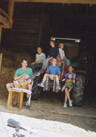 PraktikantInnenhilfe - Junger Mann beim Musizieren mit Kindern; 2000