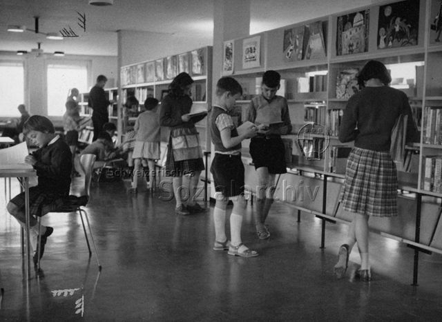 "Filiale Altstetten, Abteilung für Kinder" - Kinder beim Stöbern und Lesen in der Bibliothek; um 1965