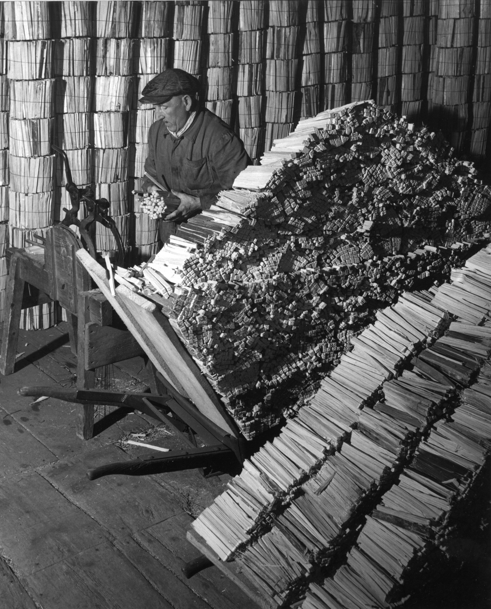 Mann beim Bündeln von Holz in einem Brennholz-Lager