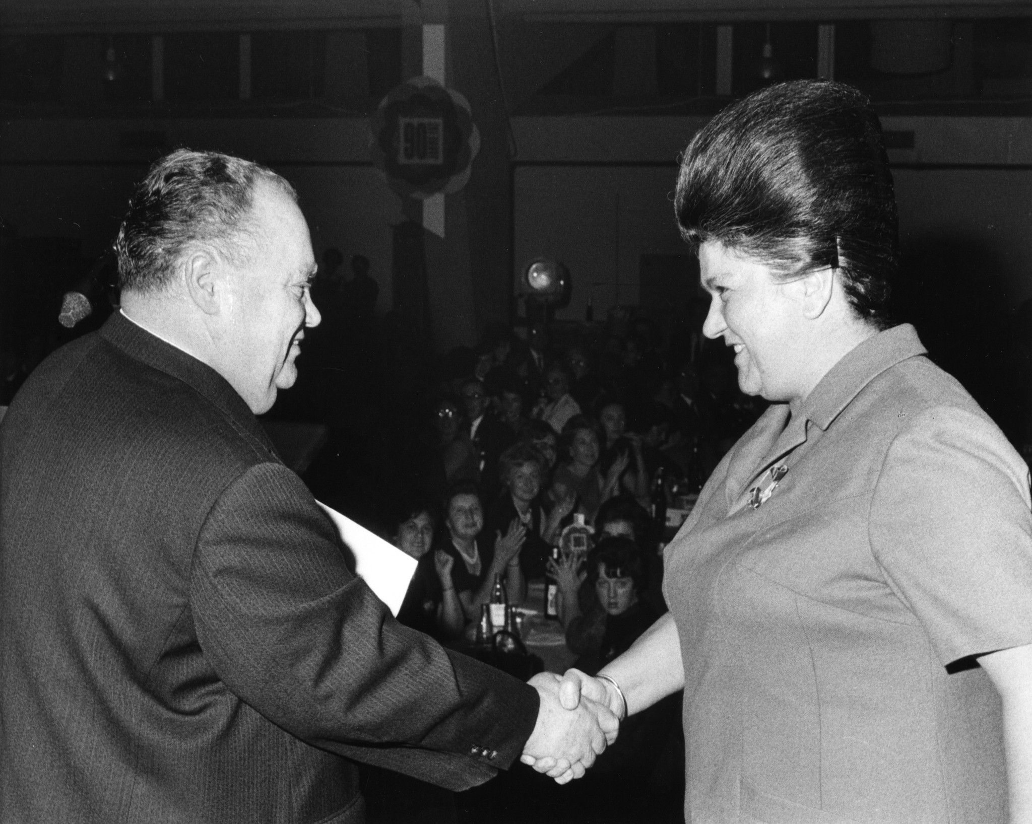 Jubiläum 90 Jahre Lebensmittelverein Zürich 1968: Mann beim Ehren einer Frau auf der Bühne