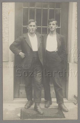 Zwei junge Männer, rauchend, vor Türe (Kontext unbestimmt), um 1910
