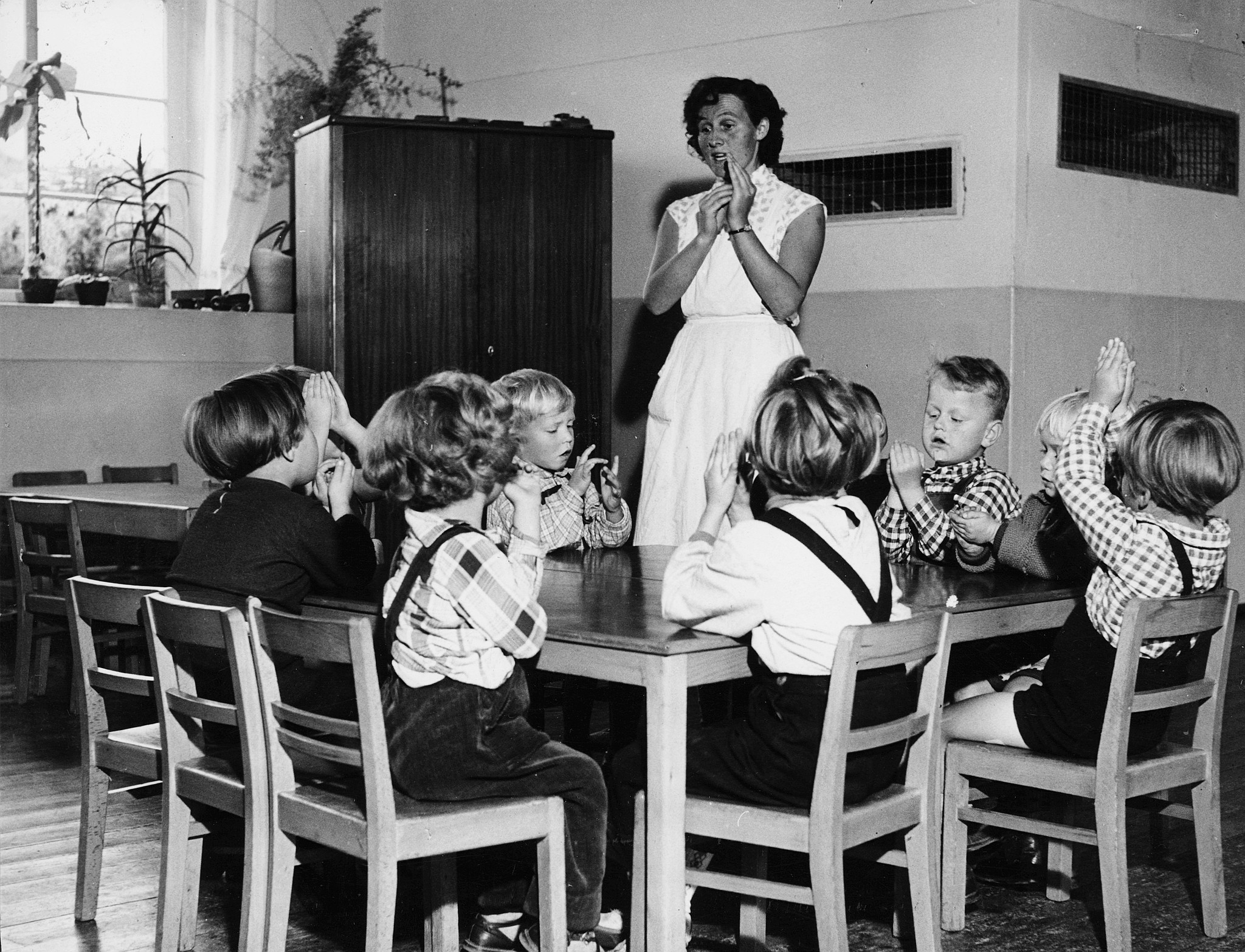 Arbeiterwohlfahrt: "Haus der Jugend" im Flüchtlingslager Ulm-Wilhelmsburg; Kinder mit Lehrerin spielend / lernend