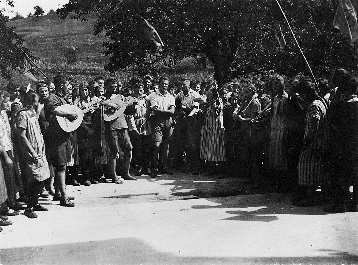 Wandervogel-Landsgemeinde in Adetswil - Versammelte Wandervögel im Kreis (einige Wandervögel spielen Gitarre, Geige und Mandoline) (