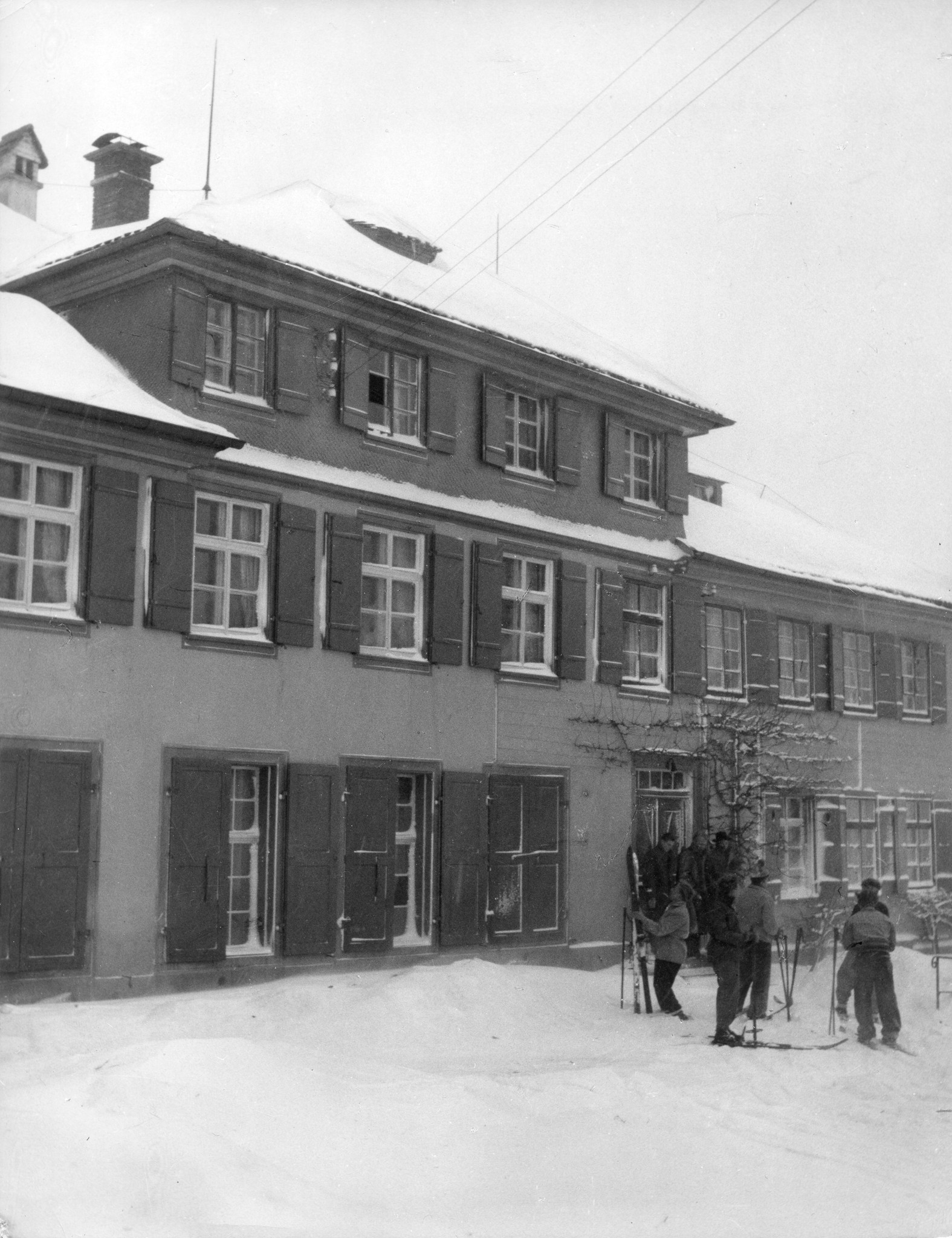 Erholungsaktion für jugendliche deutsche Flüchtlinge im Ferienhaus Lindenbühl 1952/1953; "Kurs deutscher Burschen 1952/1953"; Jugendliche in Skimontur vor dem Ferienhaus stehend