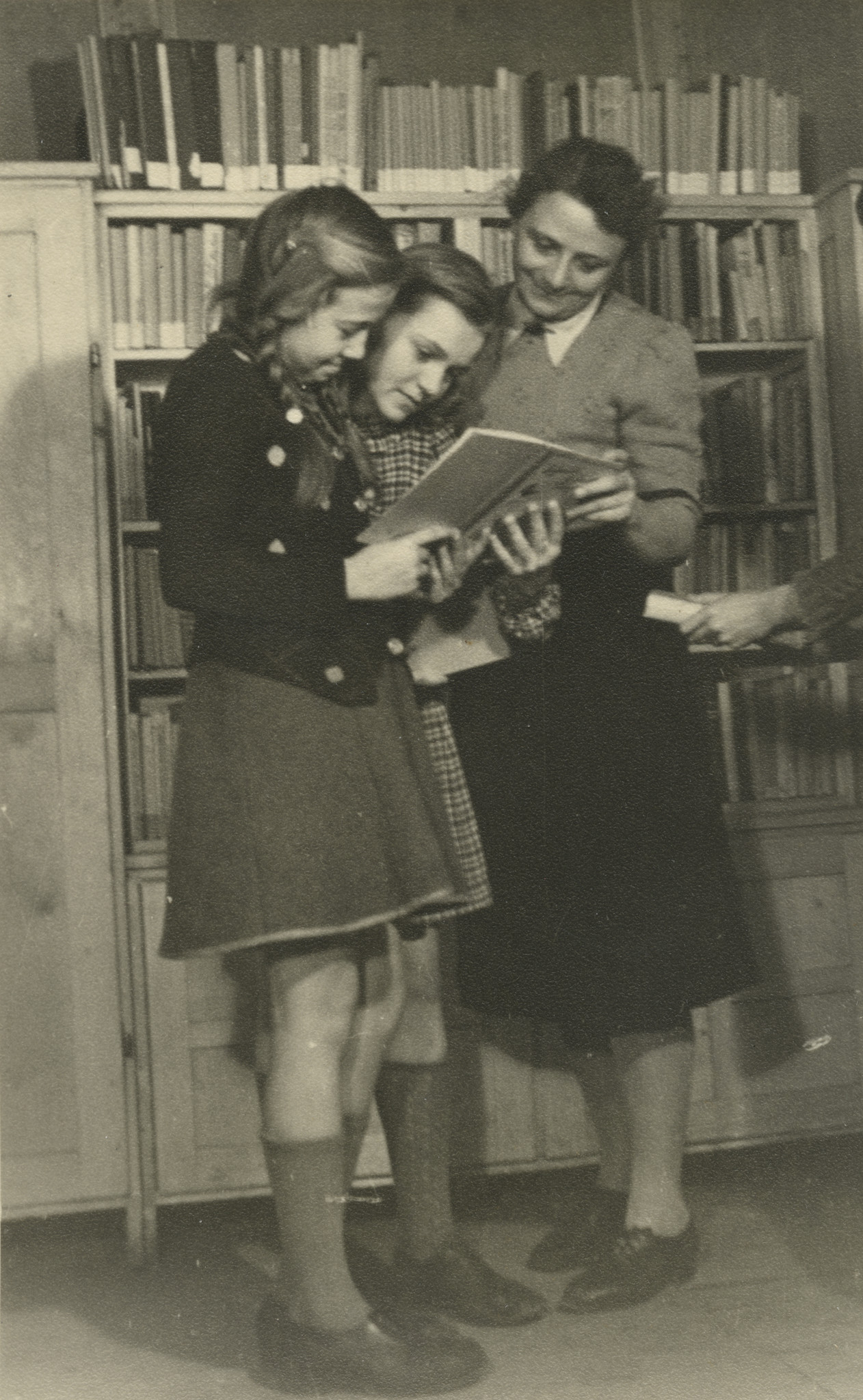 "Köln 1949 - Lesestube"; drei Mädchen lesen in einem Buch