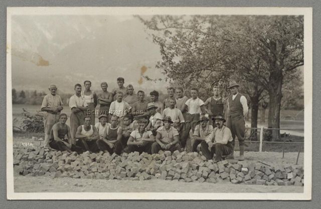 Gruppenporträt von Strassenbauarbeitern mit Pflastersteinen, Poststempel: 1933