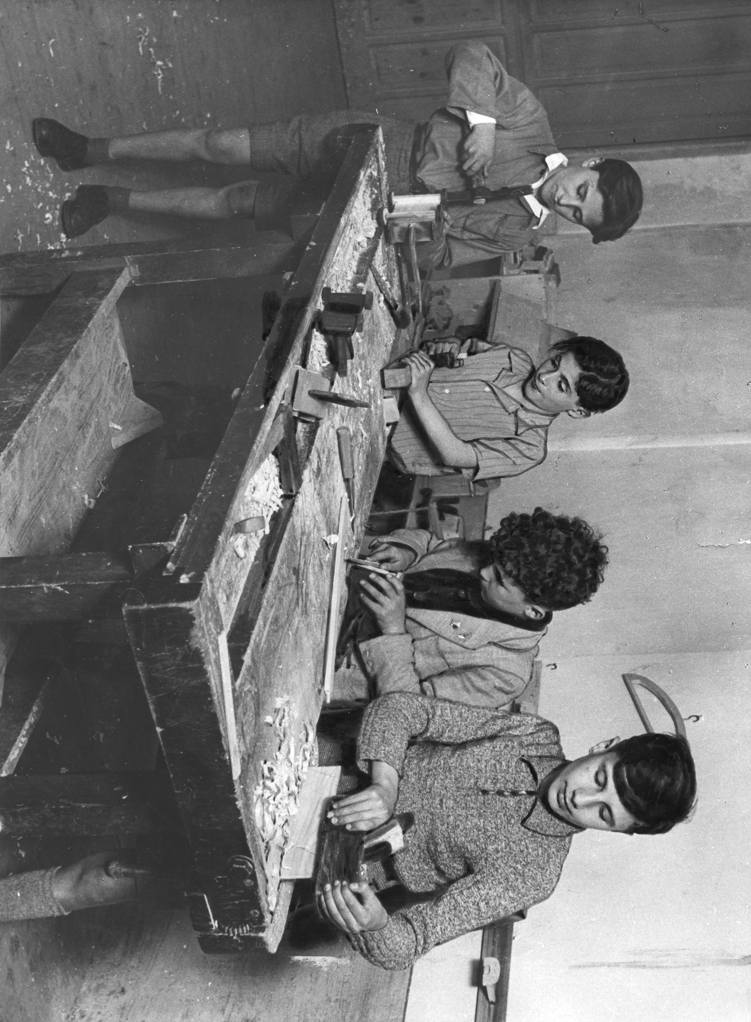 "Torino 1947: Schreinerkurs der Doposcuola. Die Hobelbank wurde vom SAH gespendet"; Knaben arbeiten an der Hobelbank