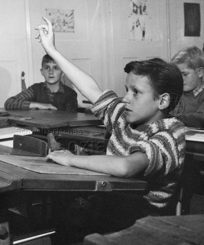 "Schule" - Ein Junge meldet sich mit aufgestrecktem Arm; um 1970
