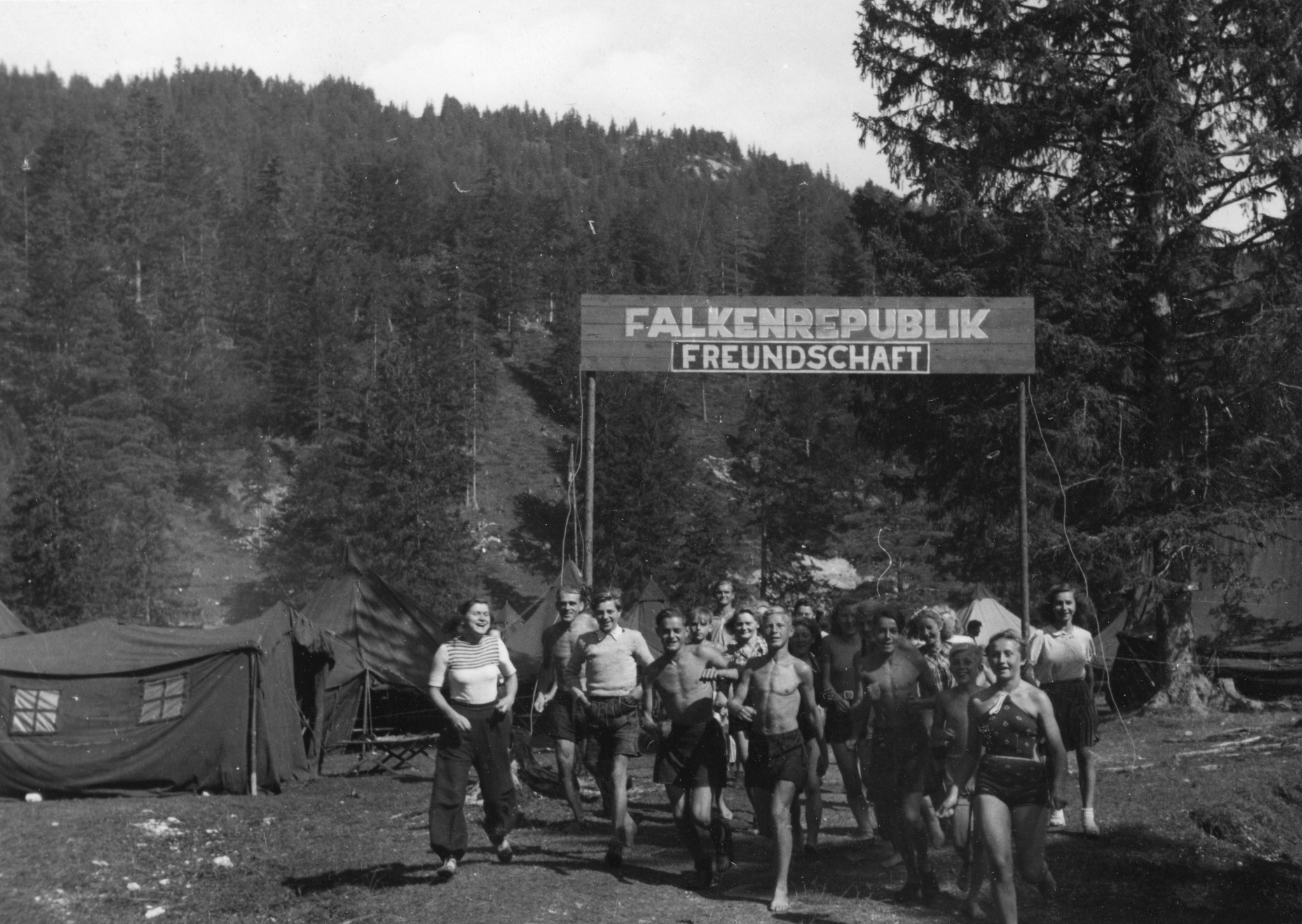 Kinder rennen in Badekleidung aus dem Lager mit der Überschrift "Falkenrepublik Freundschaft"