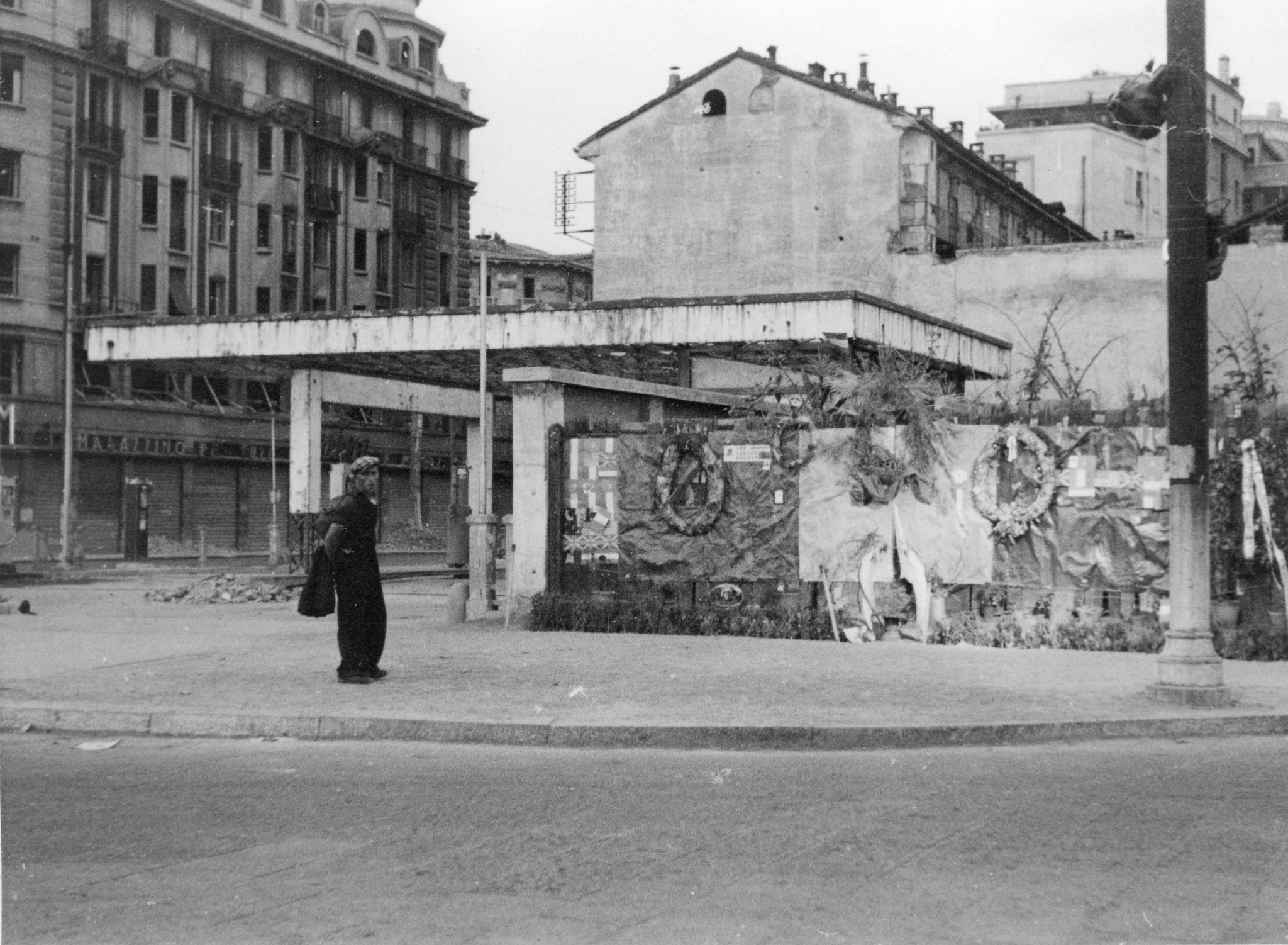 "Milano. Platz der 15 Märtyrer (vormals Platz Lorette). Neben der Wand, wo 15 Partisanen fusilliert wurden, die Garage, wo die Leichen Mussolinis und Staraces aufgehängt wurden."