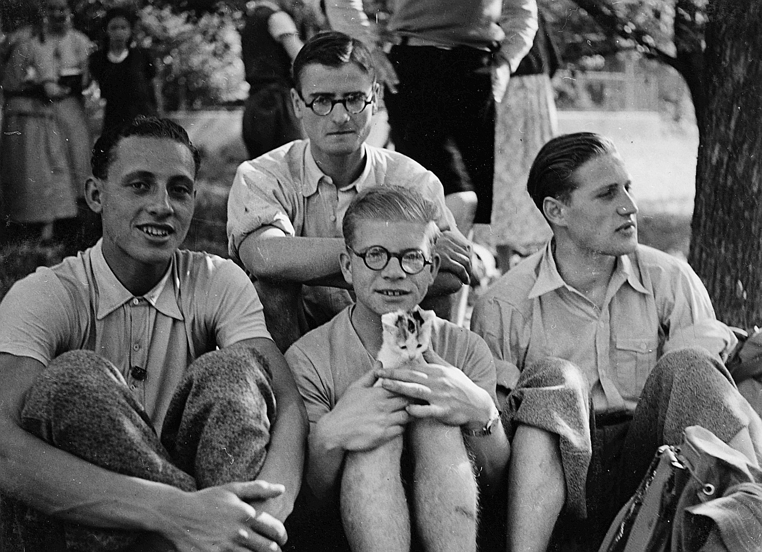 Versammelte Wandervögel sitzen auf der Wiese während der Wandervogel-Landsgemeinde in Otelfingen (1935) - Ein Bub eine Katze tragend