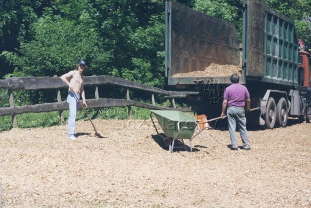 Bosco della Bella, Feriendorf für kinderreiche Familien - Zwei Männer mit Schaufeln und Schubkarre hinter Lastwagen; 2000