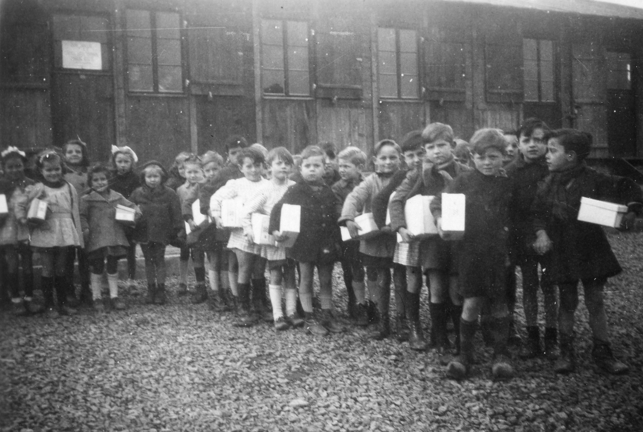 "Schuhverteilung"; Kinder stehen in einer Schlange mit Schuhkartons