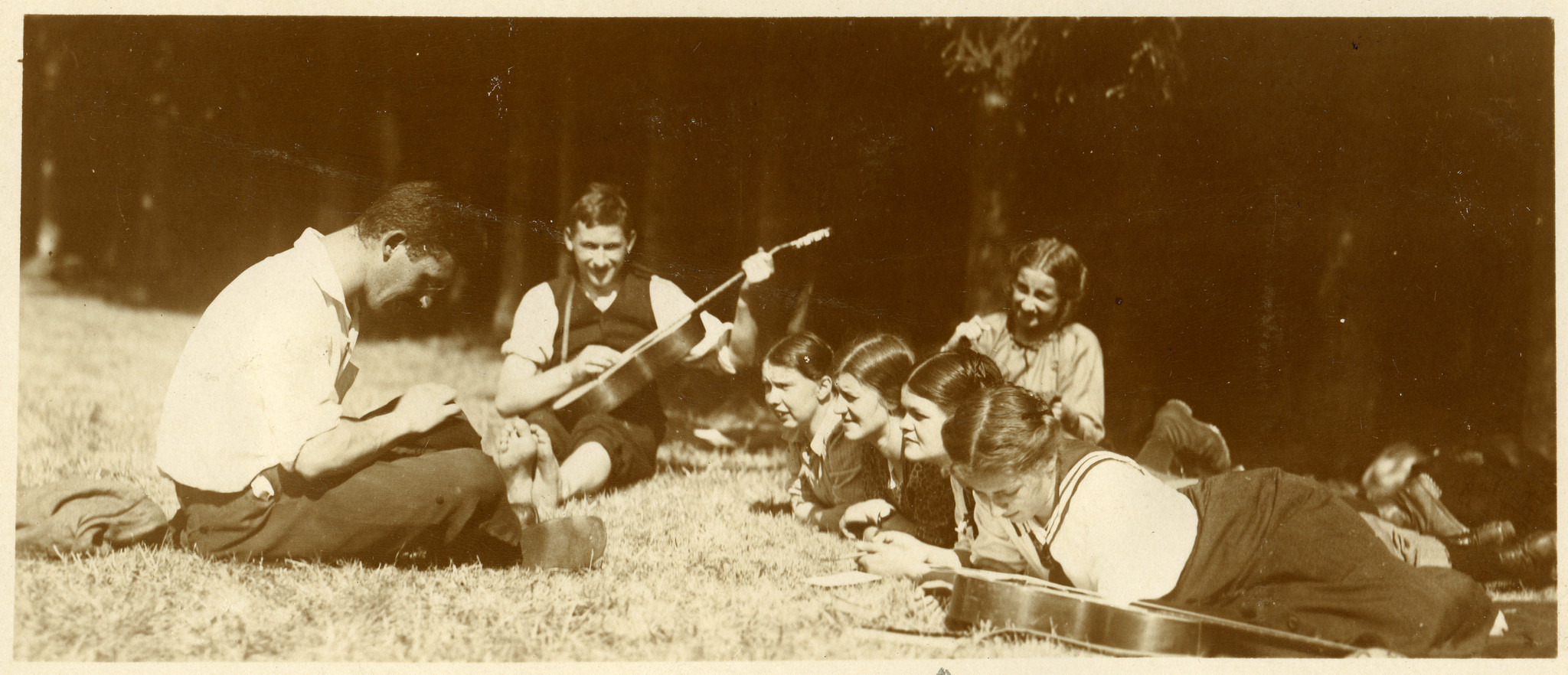 Wandervögel der Ortsgruppe Winterthur auf der Wiese, ein Junge Gitarre spielend (1912 oder 1914)